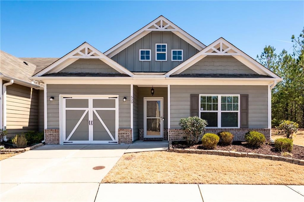 Craftsman-style home featuring driveway, brick sid