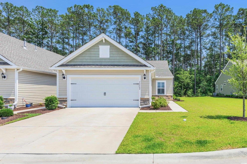 Craftsman house with a garage, concrete driveway, a front yard, and stone siding