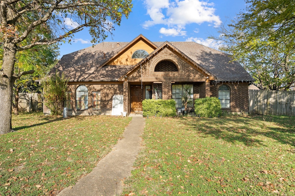 View of front facade with brick siding and a shingled roof