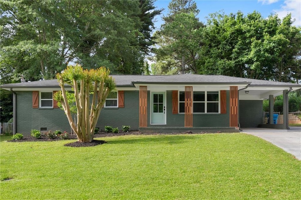 View of front facade with concrete driveway, a front yard, brick siding, and an attached carport