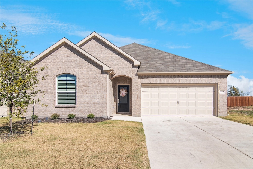 Single story home featuring brick siding, driveway, and an attached garage