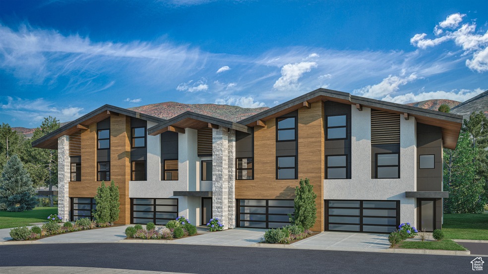 View of building exterior featuring a mountain view, driveway, and an attached garage