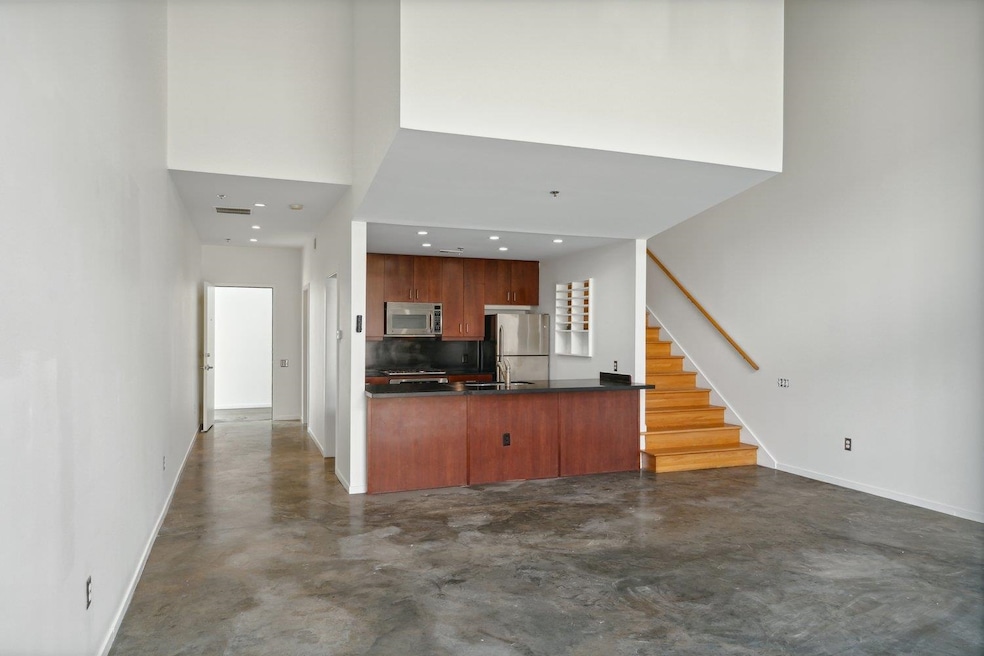 Kitchen with backsplash, a towering ceiling, appli