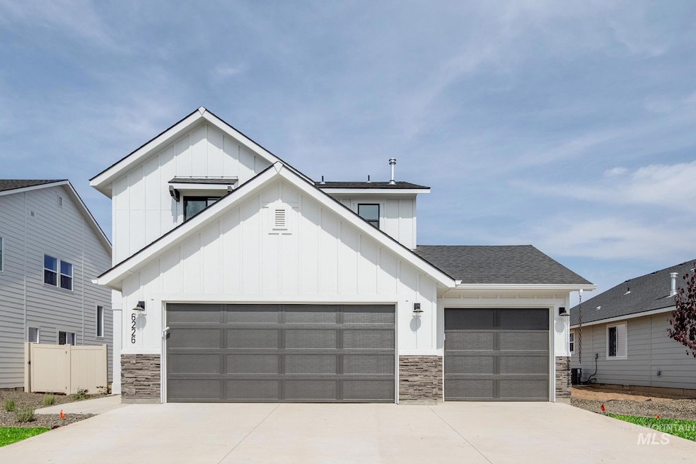 Modern farmhouse featuring board and batten siding, stone siding, a shingled roof, driveway, and a garage