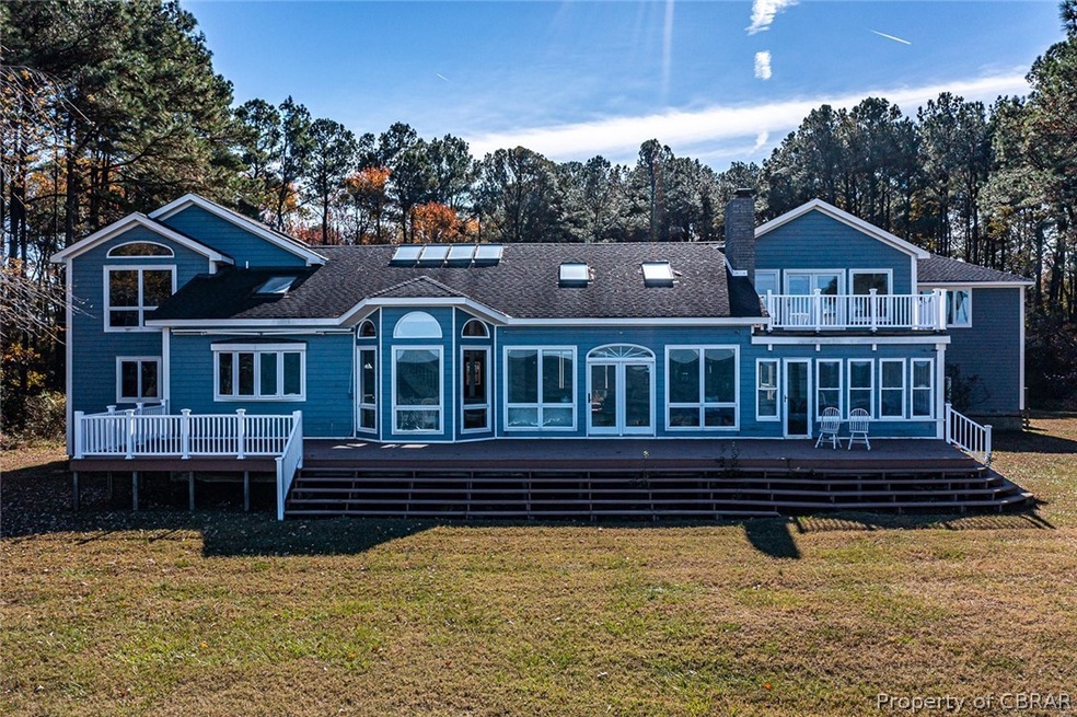 Rear view of property featuring a wooden deck, a l