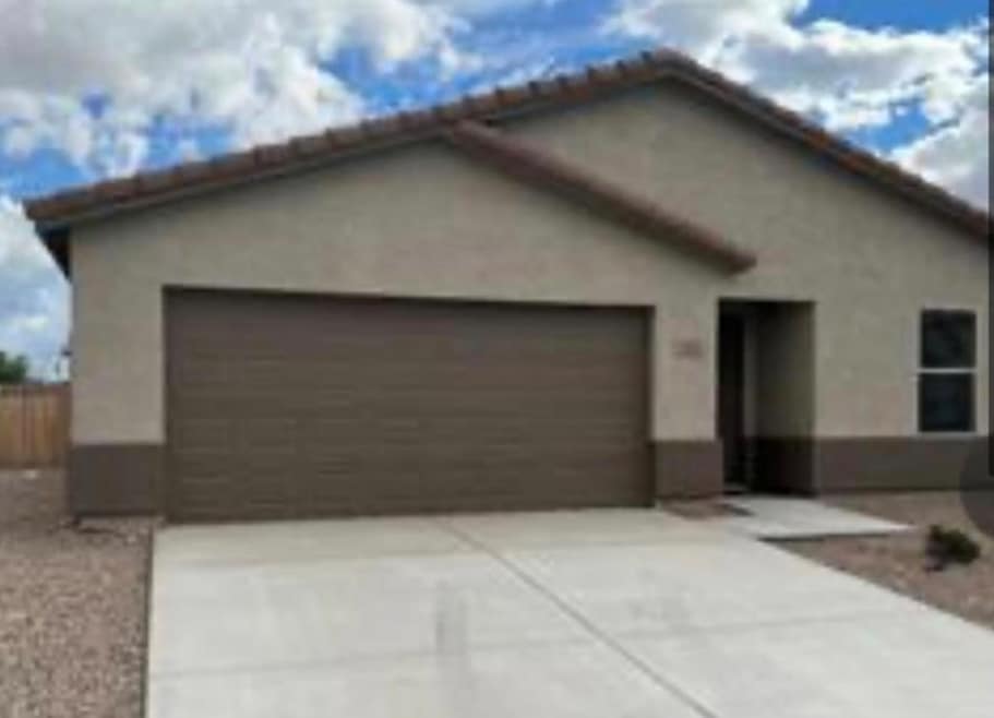 Ranch-style home with stucco siding, a tile roof,