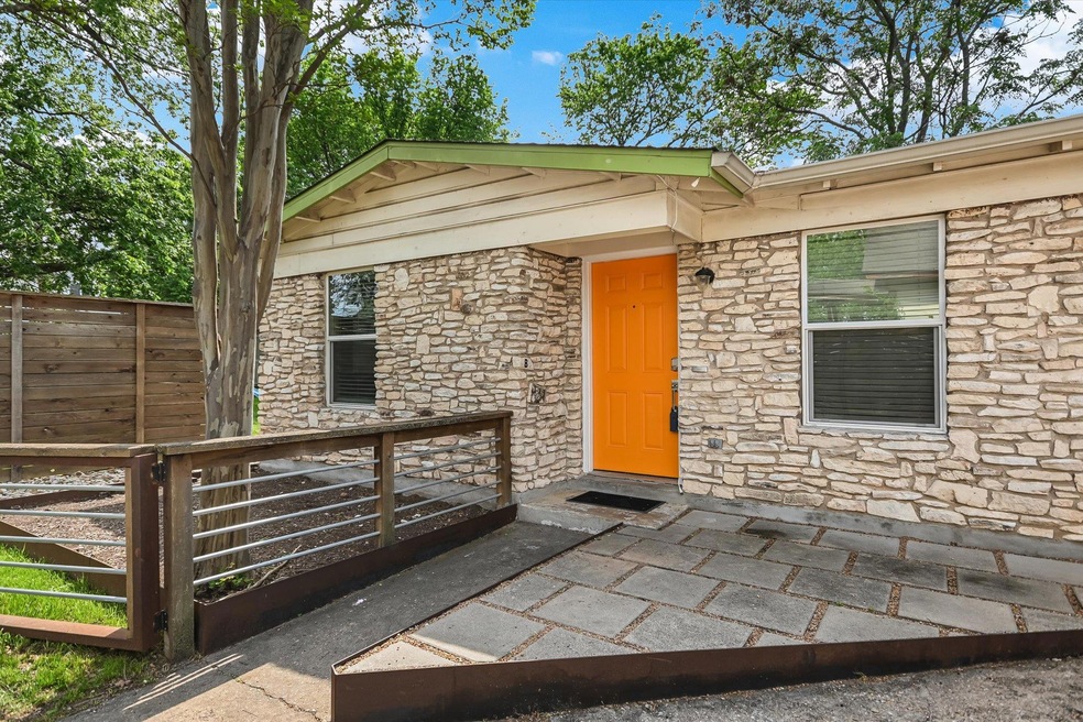 Property entrance with stone siding and fence