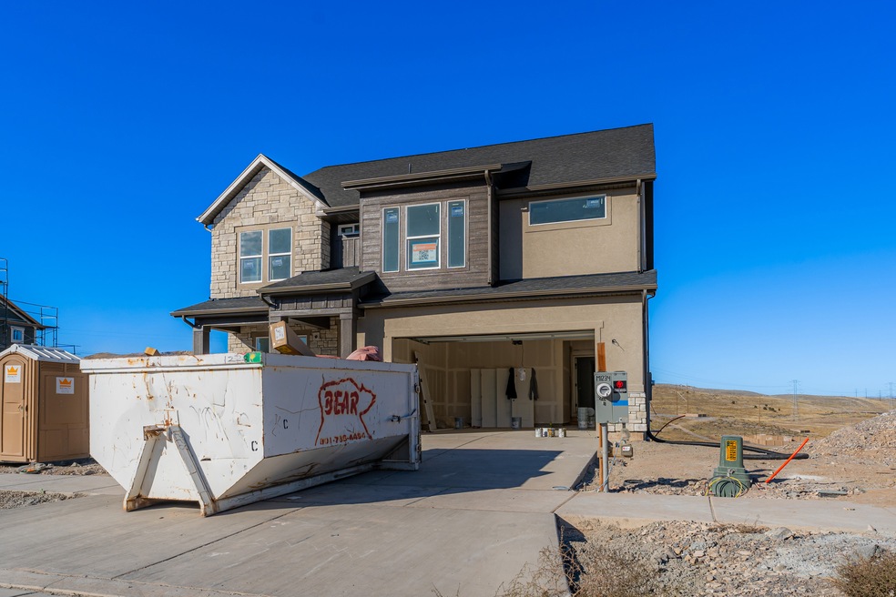 View of front of property with stone siding, concrete driveway, and a garage
