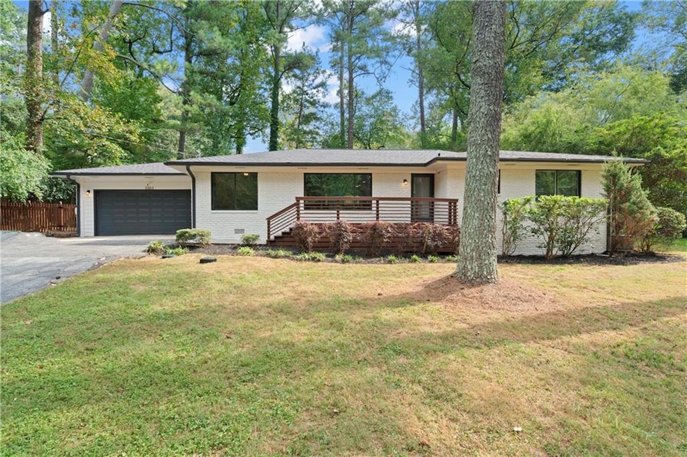 Ranch-style house featuring a front yard and a gar