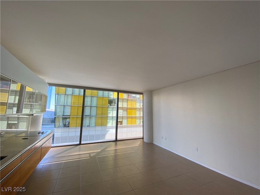Unfurnished room featuring baseboards and dark til