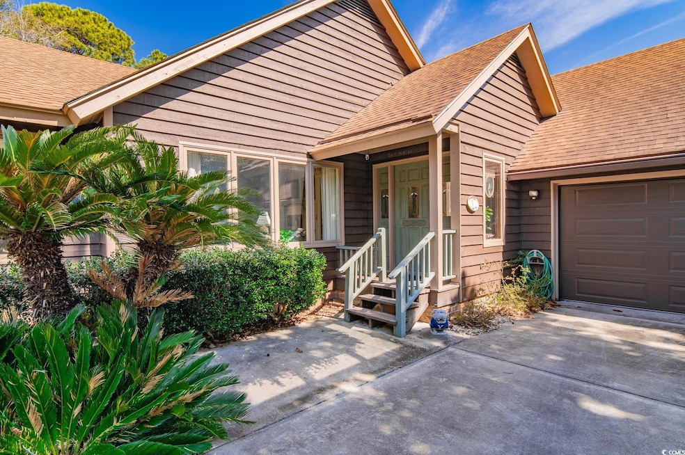 Doorway to property with a garage, roof with shing