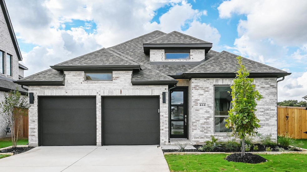 French country inspired facade with a shingled roof, concrete driveway, and an attached garage
