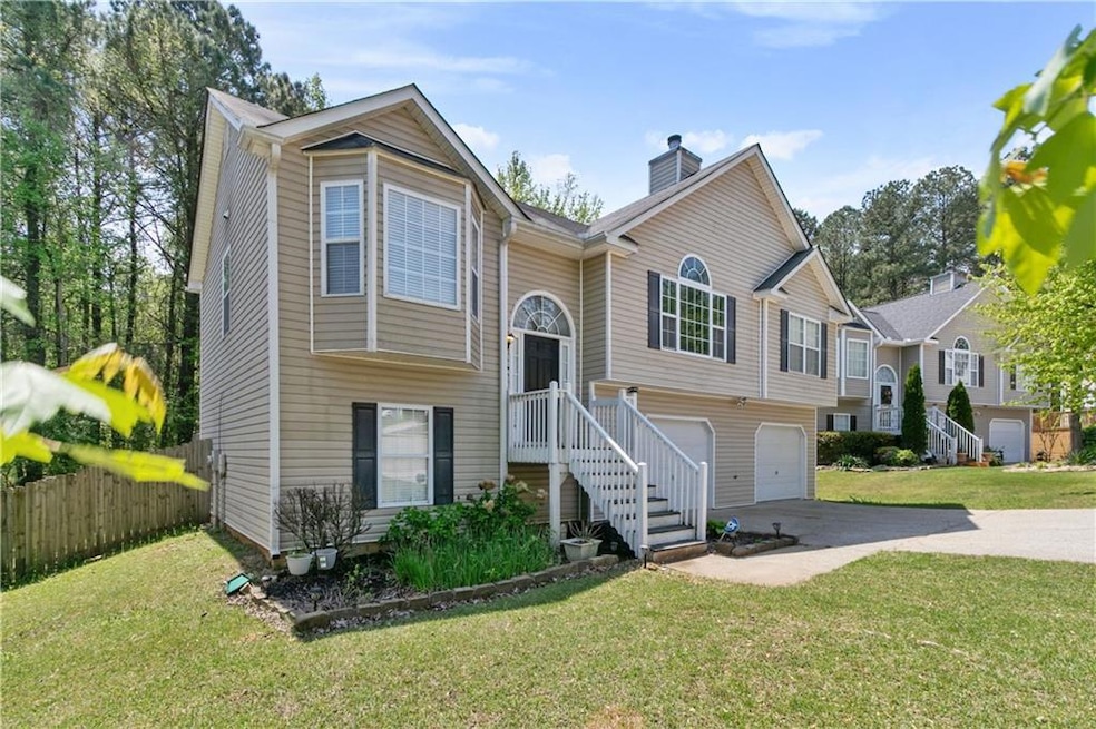 Bi-level home featuring a chimney, concrete drivew