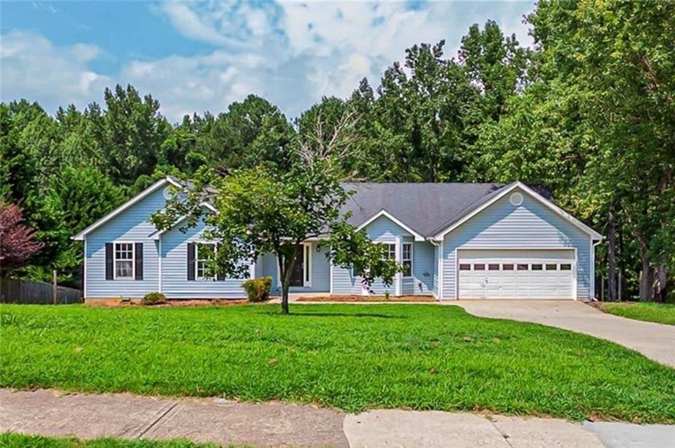 Single story home featuring a garage and a front y