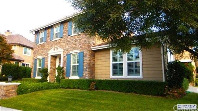 English cottage exterior with stone and shutters.