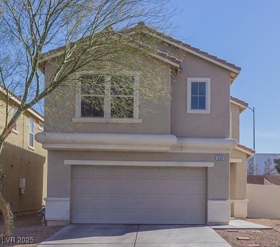 Traditional home with a garage, stucco siding, and