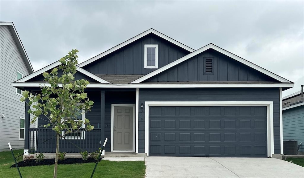 View of front of house with board and batten siding, driveway, a front yard, and a garage