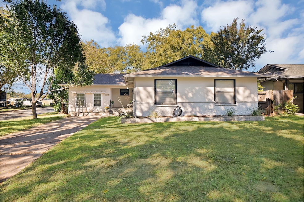 View of front facade featuring a front lawn, roof with shingles, and stucco exterior