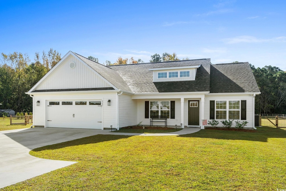 View of front facade with concrete driveway, roof with shingles, a porch, a garage, and board and batten siding