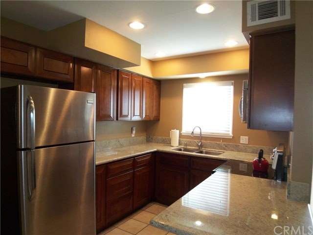 Lovely kitchen with warm-toned maple cabinets, gra