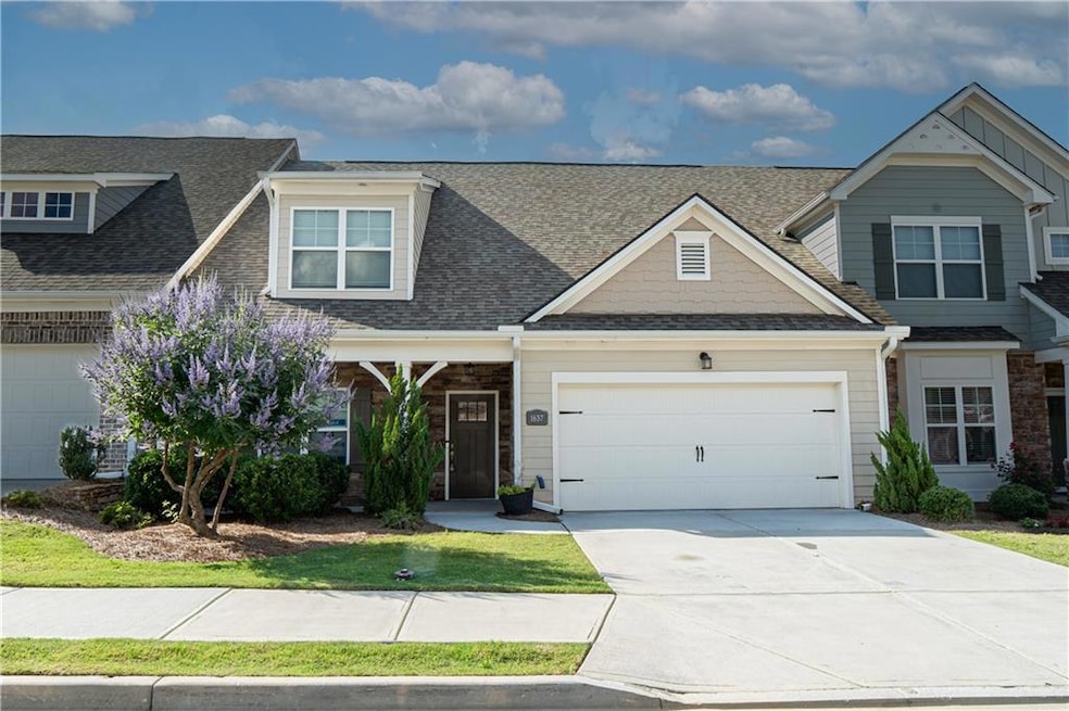 Craftsman inspired home with an attached garage, concrete driveway, a shingled roof, and stone siding