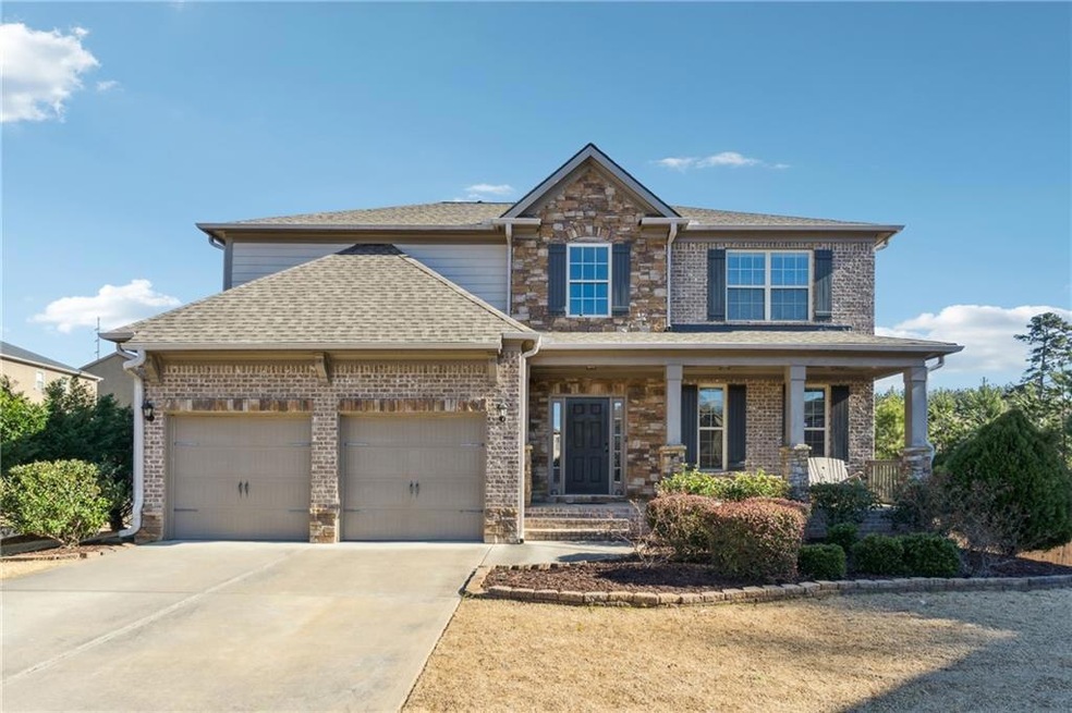 Craftsman-style home featuring a garage and covere