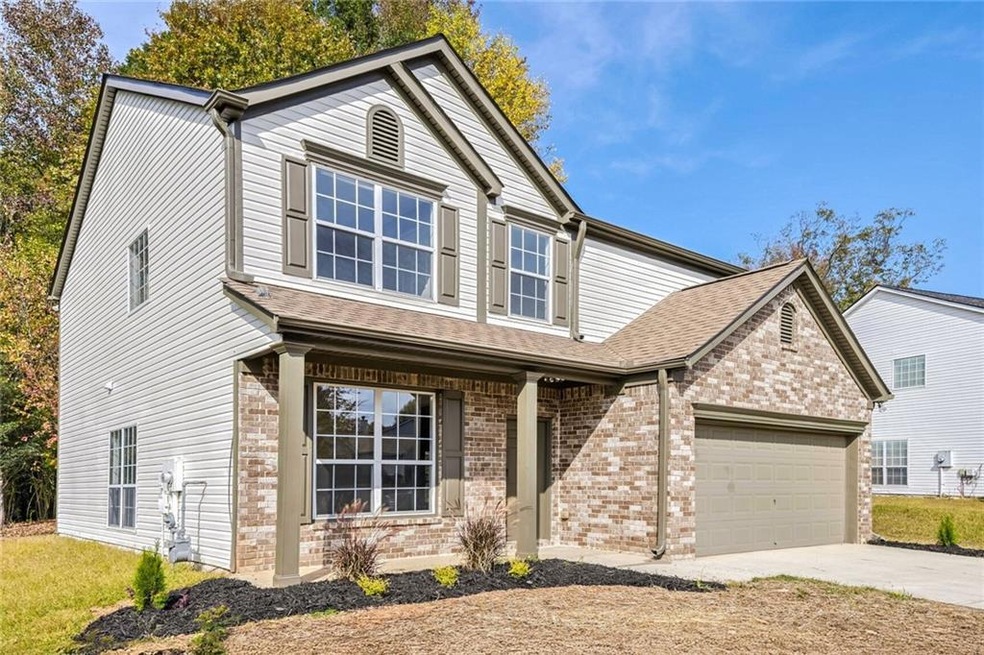 View of front of home featuring a garage and cover