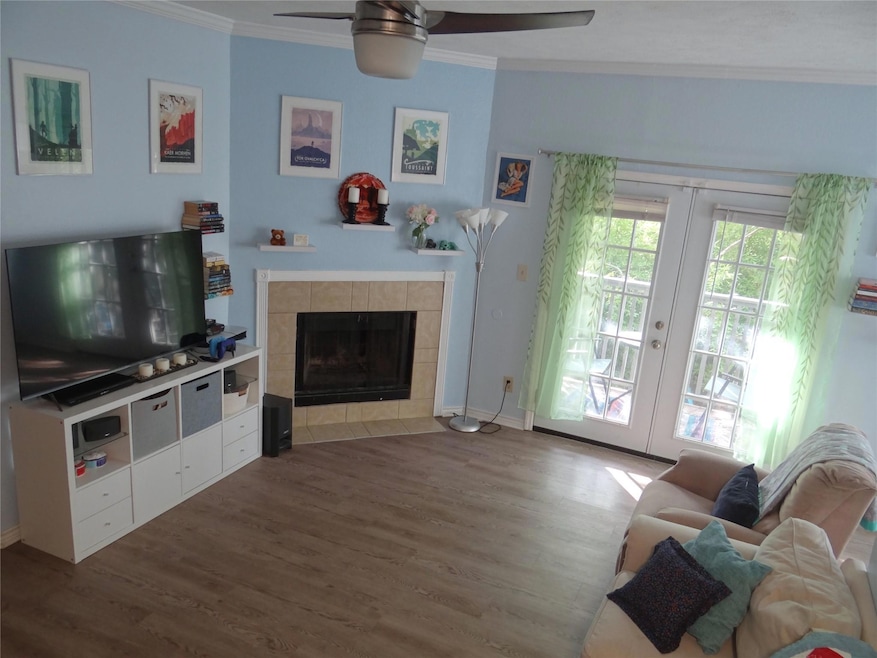 Living room with crown molding, wood finished flo