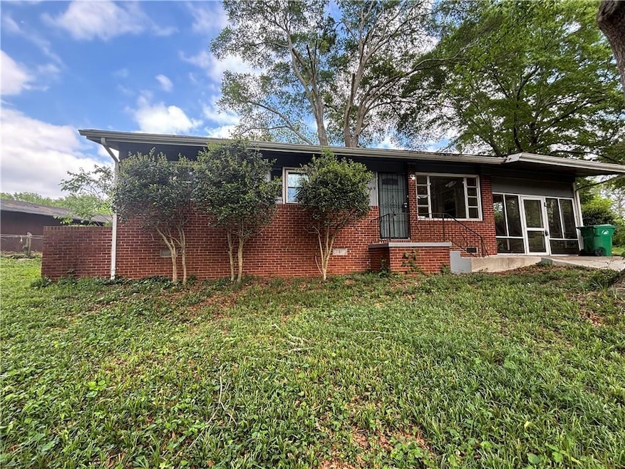 Rear view of house with a yard, brick siding, and 
