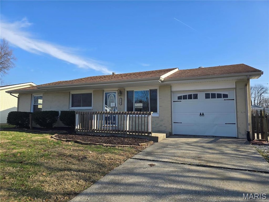Ranch-style house featuring a front yard and a garage