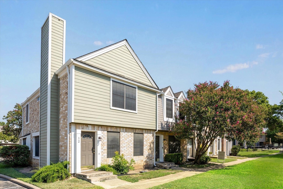 View of front of property featuring a chimney, a front yard, and brick siding