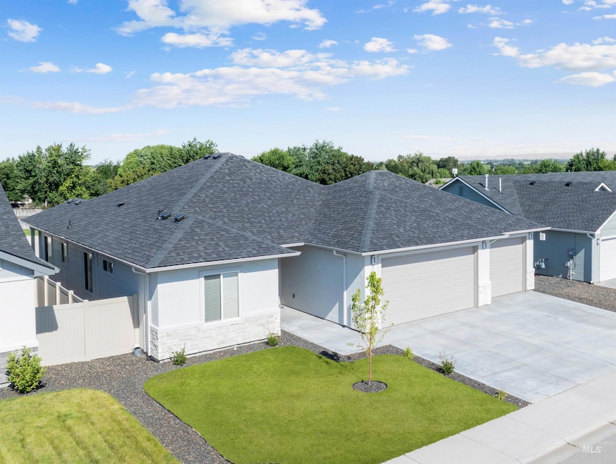 Single story home featuring a shingled roof, an attached garage, stucco siding, concrete driveway, and stone siding