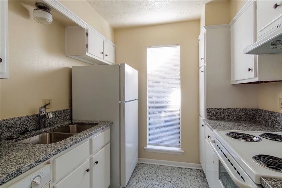 Kitchen with white appliances, stone countertops,