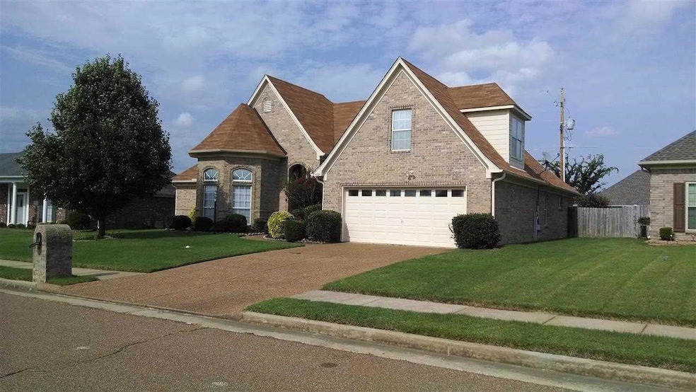 View of front of home with a garage, concrete driveway, and brick siding