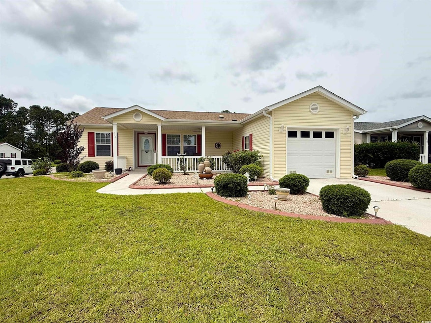 Ranch-style home featuring covered porch, a garage, driveway, and a front yard