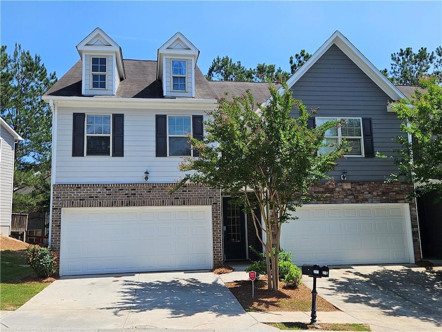 View of front of home with an attached garage, concrete driveway, and brick siding