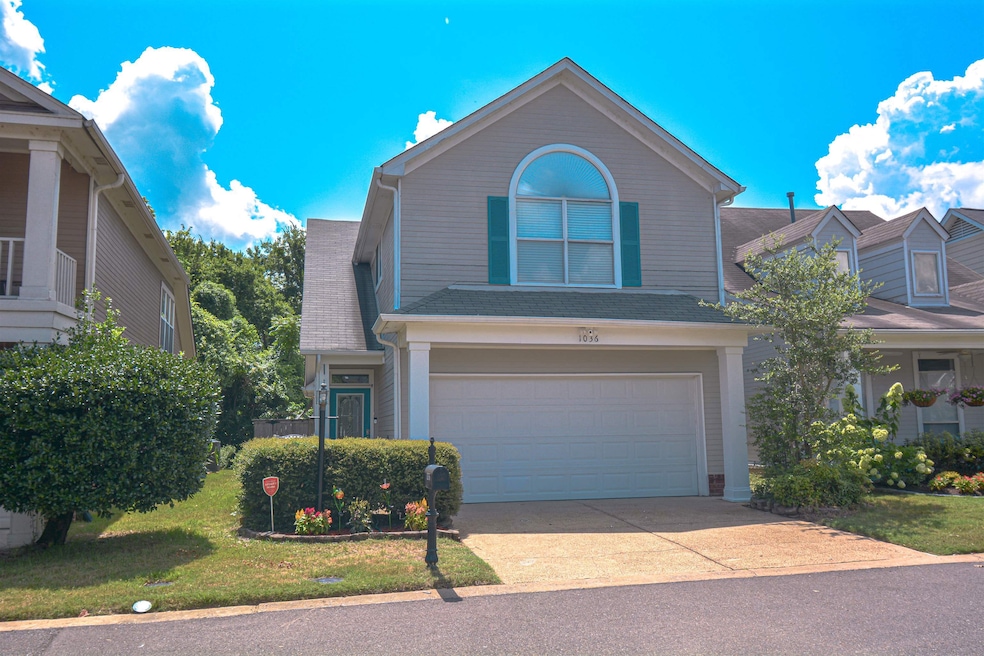 Traditional-style home featuring driveway, an attached garage, and a shingled roof