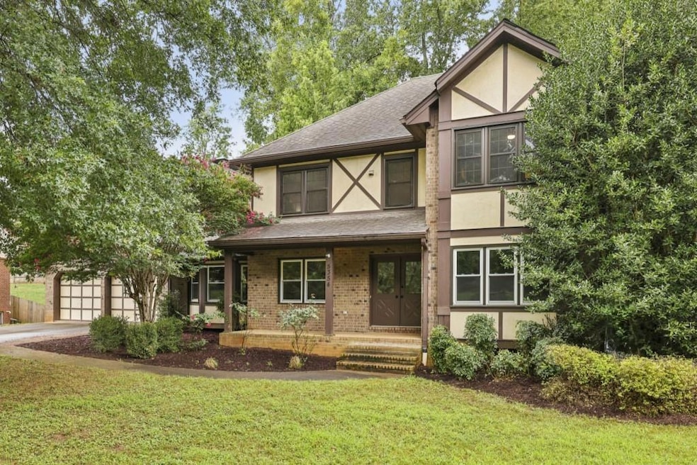 A Tudor Revival Southern Charmer with Timeless Curb Appeal and Inviting Outdoor Spaces!