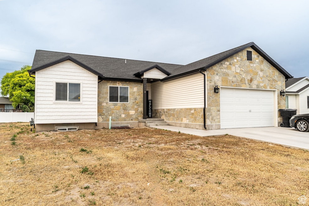 Ranch-style home with stone siding, an attached garage, driveway, and a shingled roof