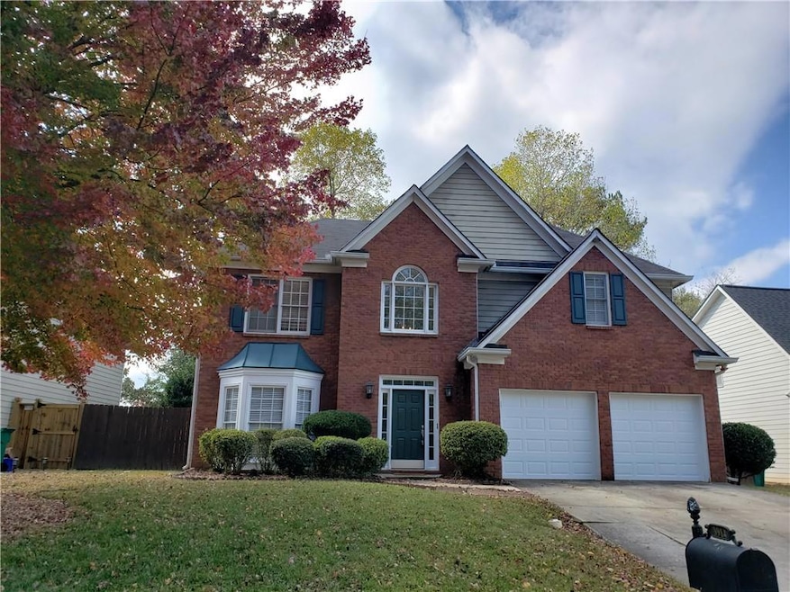 View of front of property featuring a garage and a front yard