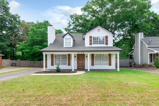 View of front of home featuring a porch, driveway, a chimney, and roof with shingles