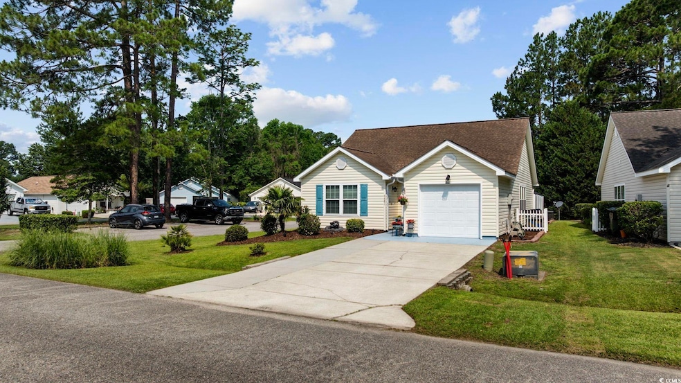 View of front of home featuring concrete driveway, a front yard, an attached garage, and roof with shingles