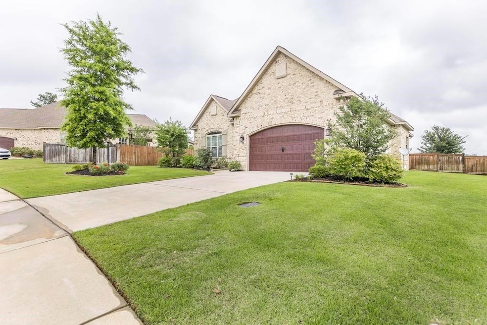 French provincial home with driveway, an attached garage, and stone siding
