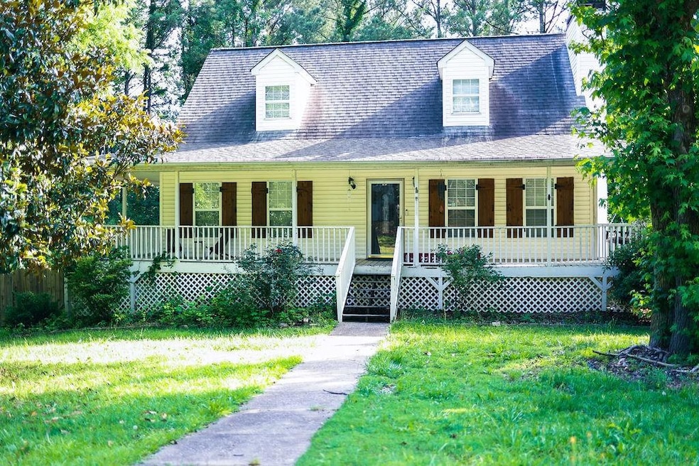 Cape cod home featuring a porch and a front yard