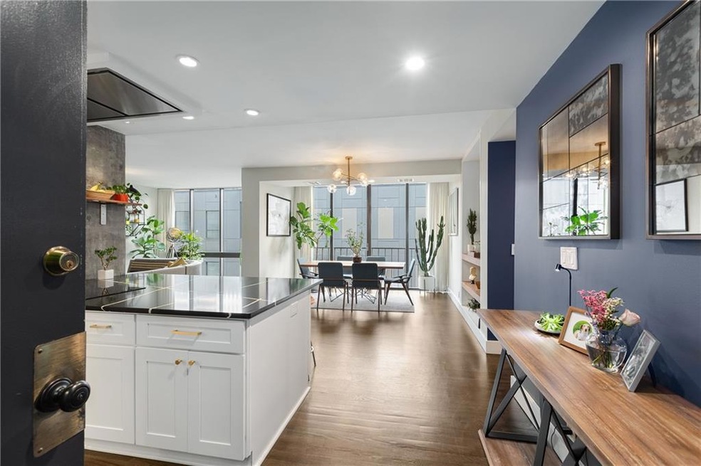 Kitchen with white cabinets, a chandelier, dark wood-style floors, dark countertops, and recessed lighting