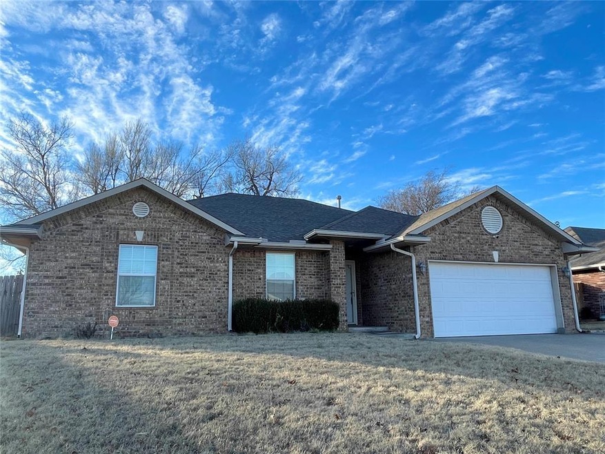 Ranch-style home featuring a front lawn and a gara