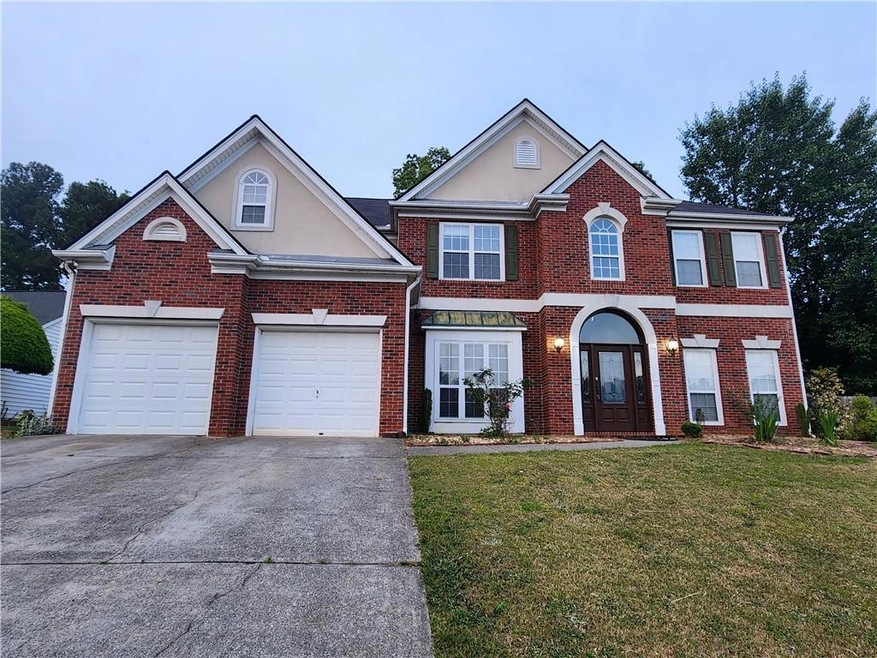 View of front of house with a garage and a front y