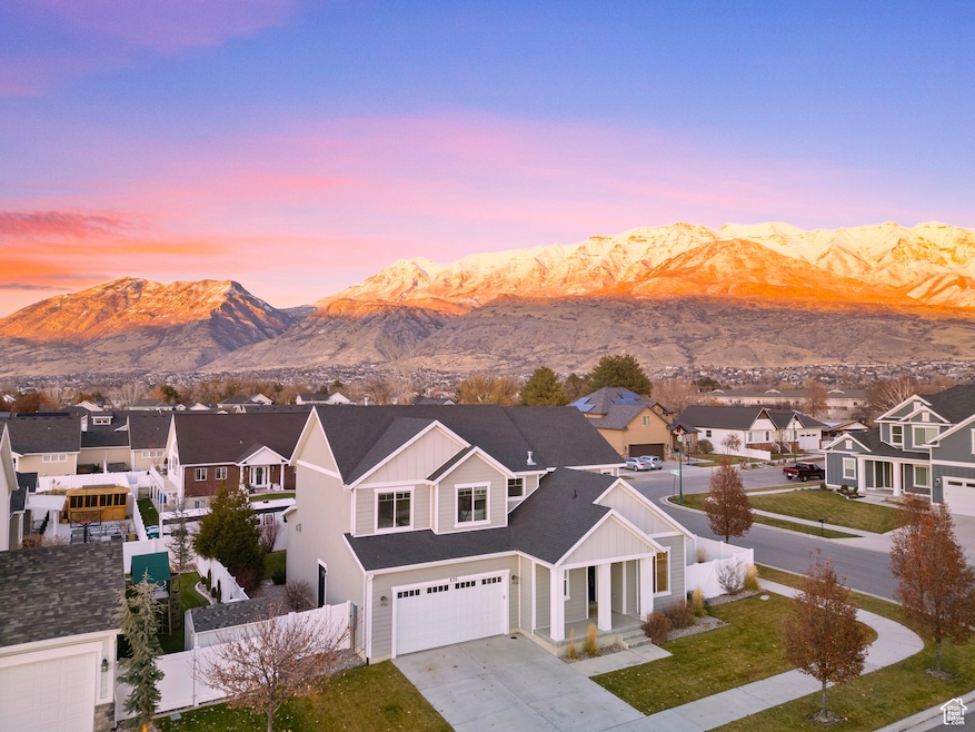 View of front of house featuring covered porch, concrete driveway, a residential view, and a mountain view