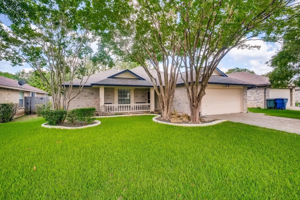 Ranch-style home with a front yard, concrete driveway, and brick siding