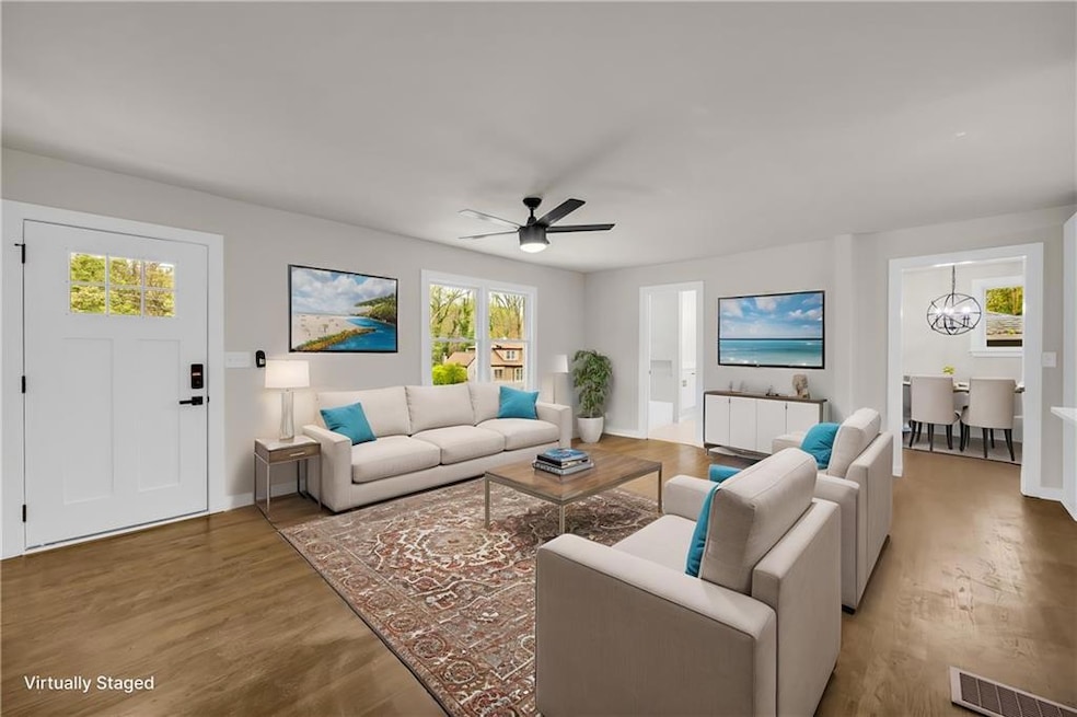 Living room featuring wood finished floors, a chandelier, and ceiling fan